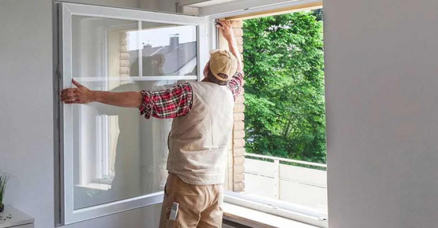 Installer setting a new window frame into the opening