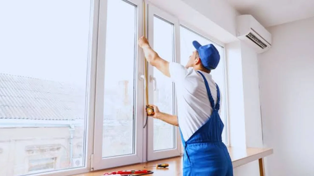 Juan Velazquez measuring a window opening in a Denver home